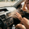 Man inside car feeling hot as warm air blows from the air conditioning vent showing 42 degrees Celsius